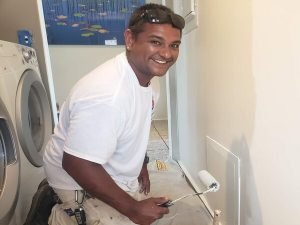 Bernardos Painting team member painting a laundry room - Bernardo's Painting