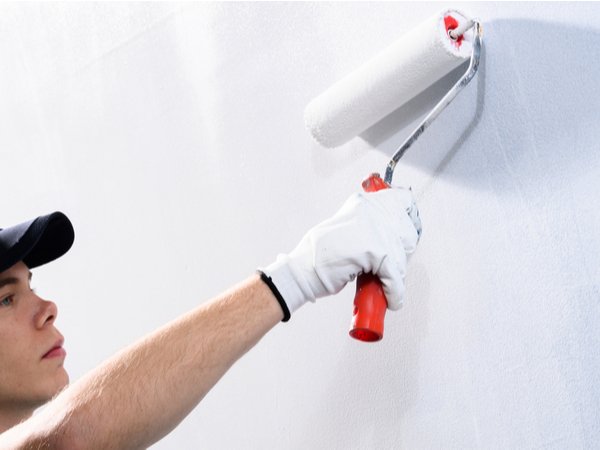 Painter fixing paint streaks on a wall