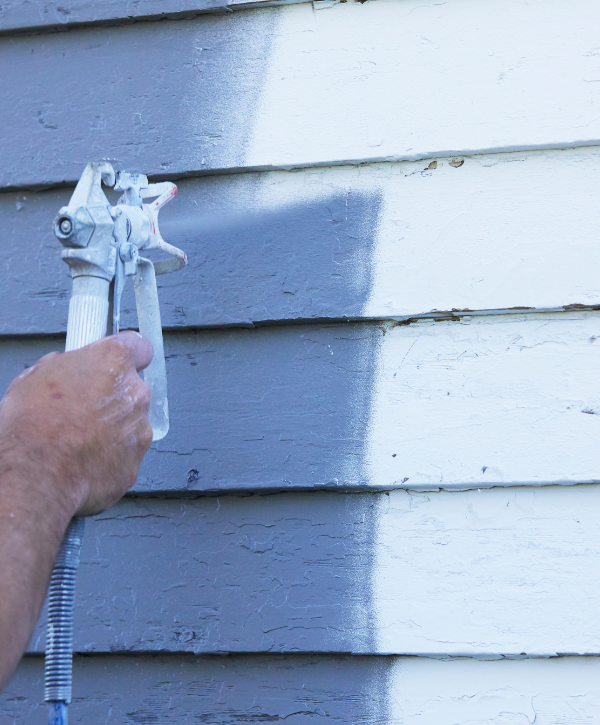 exterior painting project with a man painting a house white