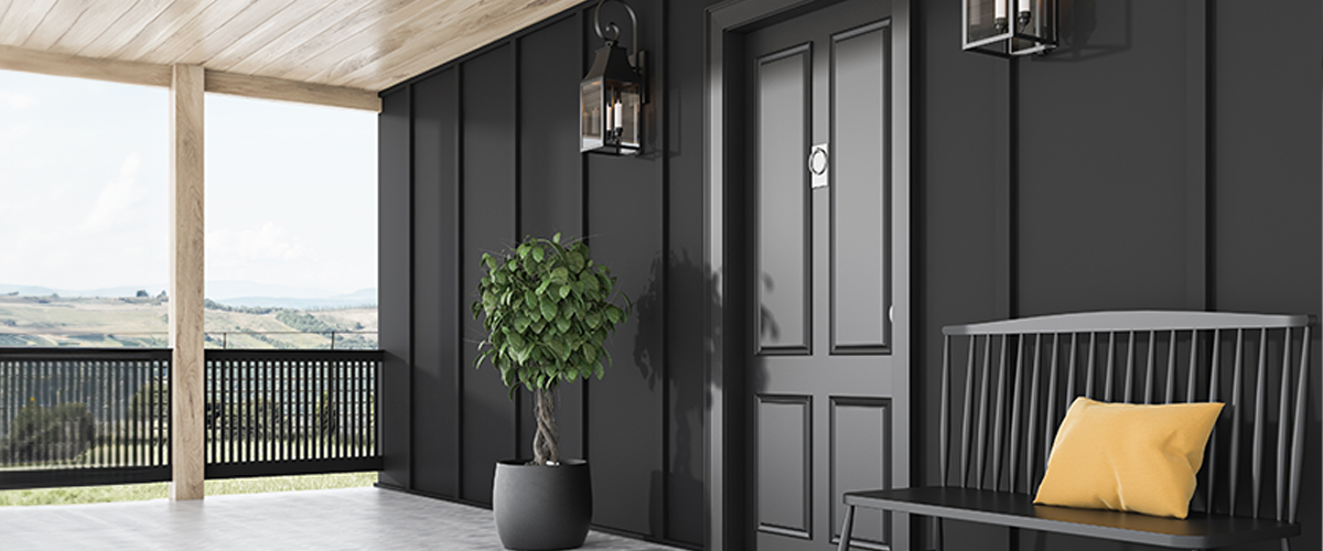 Modern exterior painted black front porch in Wahiawa, with wooden ceiling, potted plant, black bench with yellow cushion, and decorative lanterns.