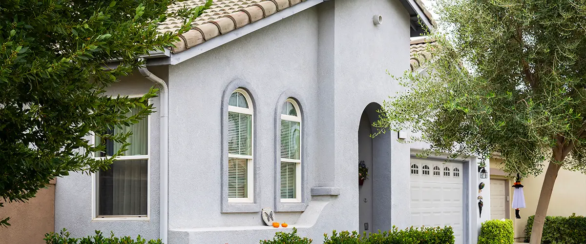 Modern suburban home with arched windows, stucco exterior, landscaped front yard, and a two-car garage for residential appeal.