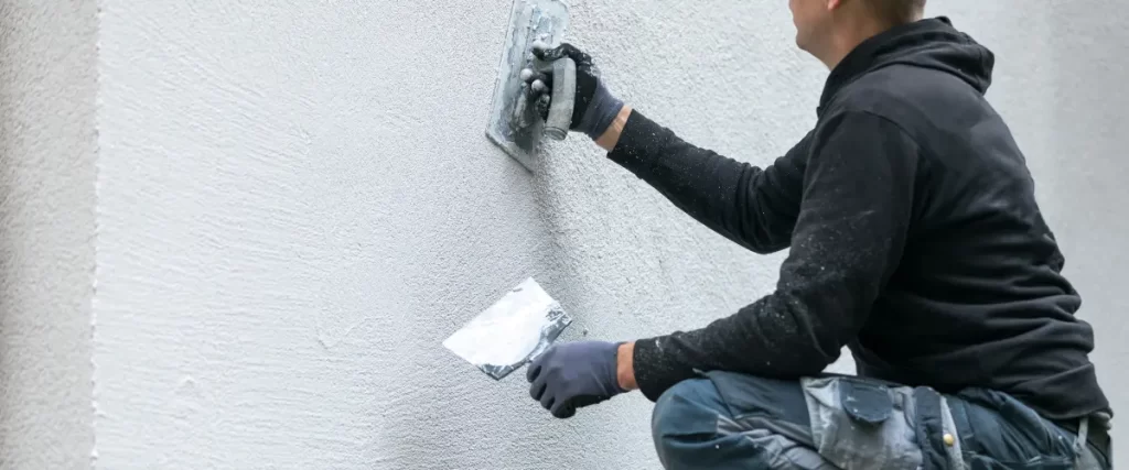 Bamboo, Lava Rock & Stucco: Painting Hawaii’s Unique Home Exteriors 3 Contractor applying stucco to exterior wall with a trowel